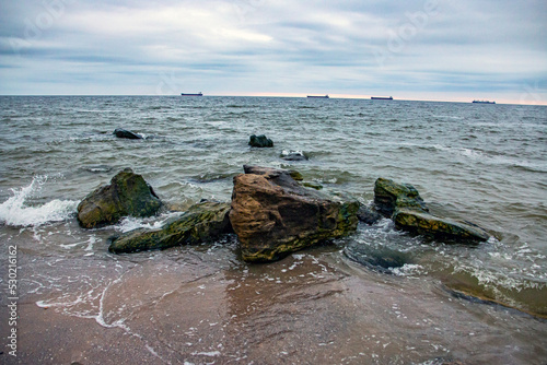 Large stones stand in sea water among the waves 