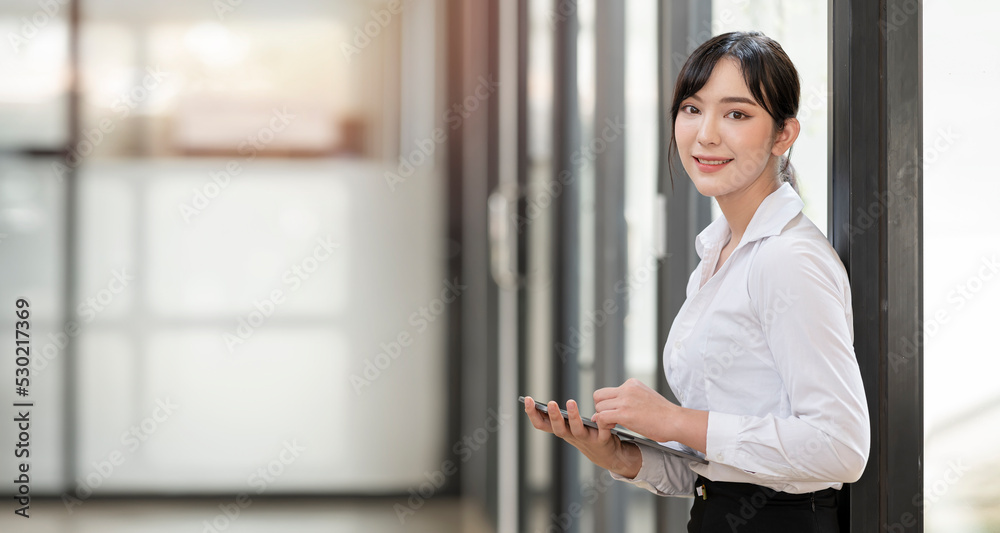 Cheerful young asian businesswoman holding digital tablet and looking at camera. Cheerful young asian businesswoman holding digital tablet and looking at camera.