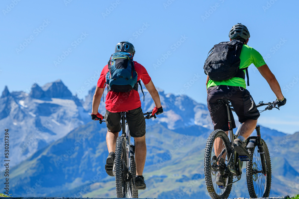 Fototapeta premium Zwei Mountainbiker vor imposanter Gebirgskulisse im Montafon