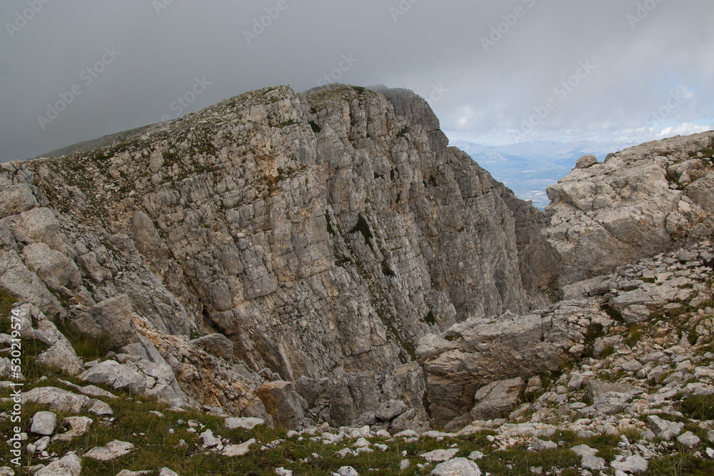 View of rocky and wild peak of Sirente mount in Abruzzo covered by clouds View of rocky and wild peak of Sirente mount in Abruzzo covered by clouds