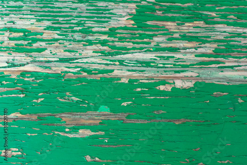 Abstract wood texture with peeling paint. Green wooden backdrop. Shabby painted wood. Close-up on the Surface of an Old Wooden Green Door. Grungy wooden texture with green paint
