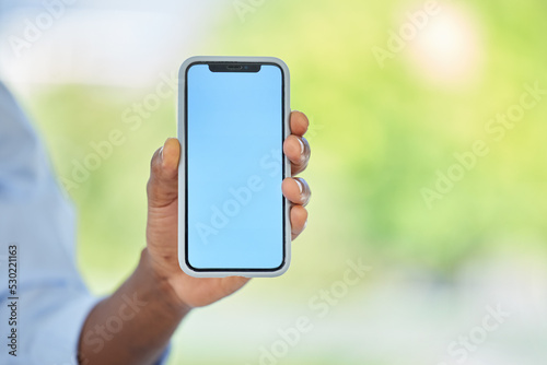 Phone, blue screen and mockup space for marketing, company website and advertising brand. Zoom on worker, hand or businessman with startup logo, internet digital search or social media app background