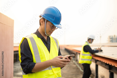 Asian man Technician wearing helmet and use smartphone for working in site work.