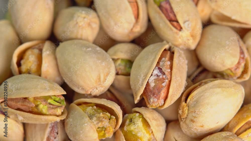 Roasted pistachios rotate on a black background. Salted pistachio nuts for beer background close up. Vegan Healthy food high protein. Dietary nutrition. Concept of nuts. Roasted pistachios rotate on a black background. Salted pistachio nuts for beer background close up. Vegan Healthy food high protein. Dietary nutrition. Concept of nuts.