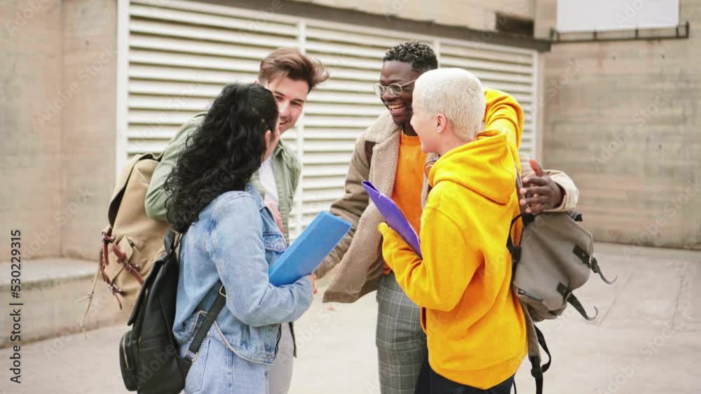 Two young students boys greeting and flirting with two friend girls at university campus. A group of teenagers laughing and talking about the class and home works at school. Education concept. High Two young students boys greeting and flirting with two friend girls at university campus. A group of teenagers laughing and talking about the class and home works at school. Education concept. High