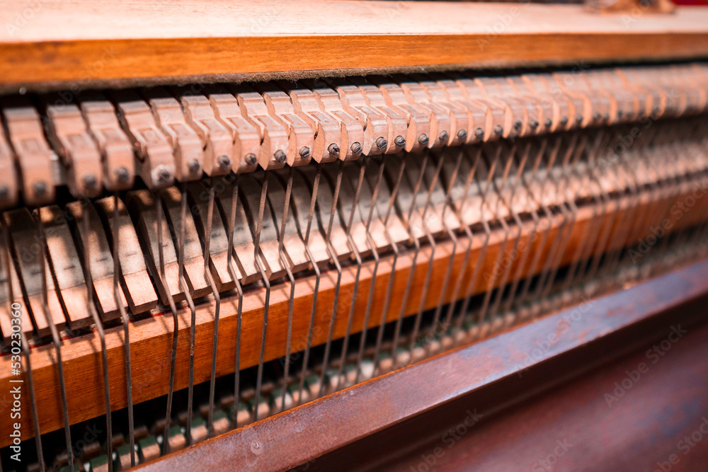 Internal part of piano with brass metal strings and wooden hammer. Old fashion music instrument for performance. Selective focus. Internal part of piano with brass metal strings and wooden hammer. Old fashion music instrument for performance. Selective focus.