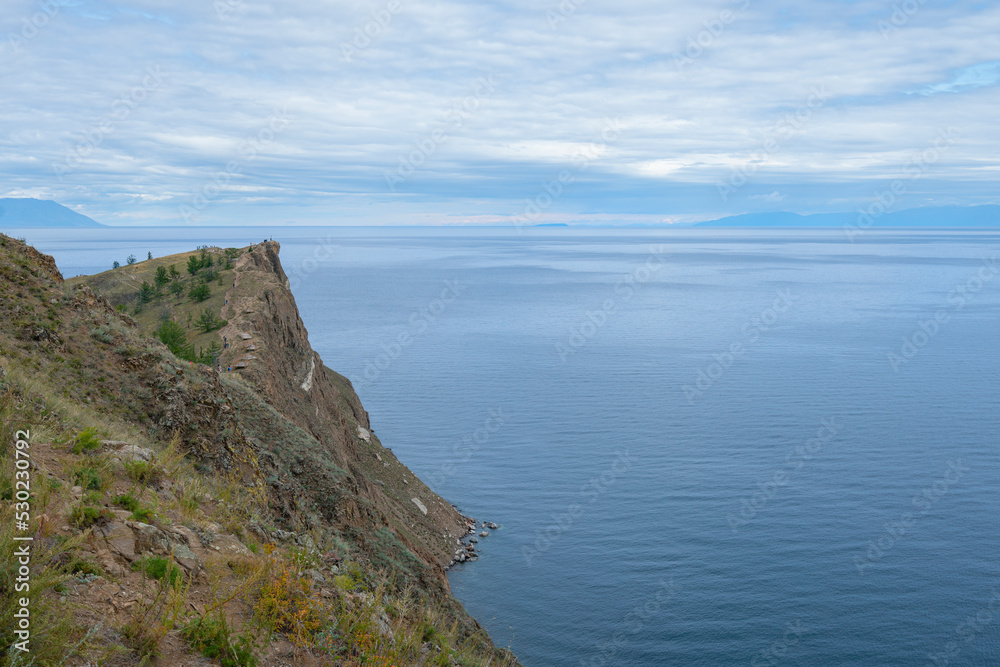 Beautiful summer landscape of Baikal Lake on sunny day. View of the rocky cape Beautiful summer landscape of Baikal Lake on sunny day. View of the rocky cape