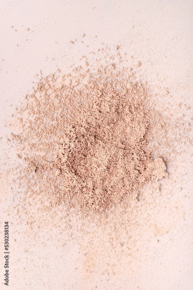 scattered skin colored powder on a light background