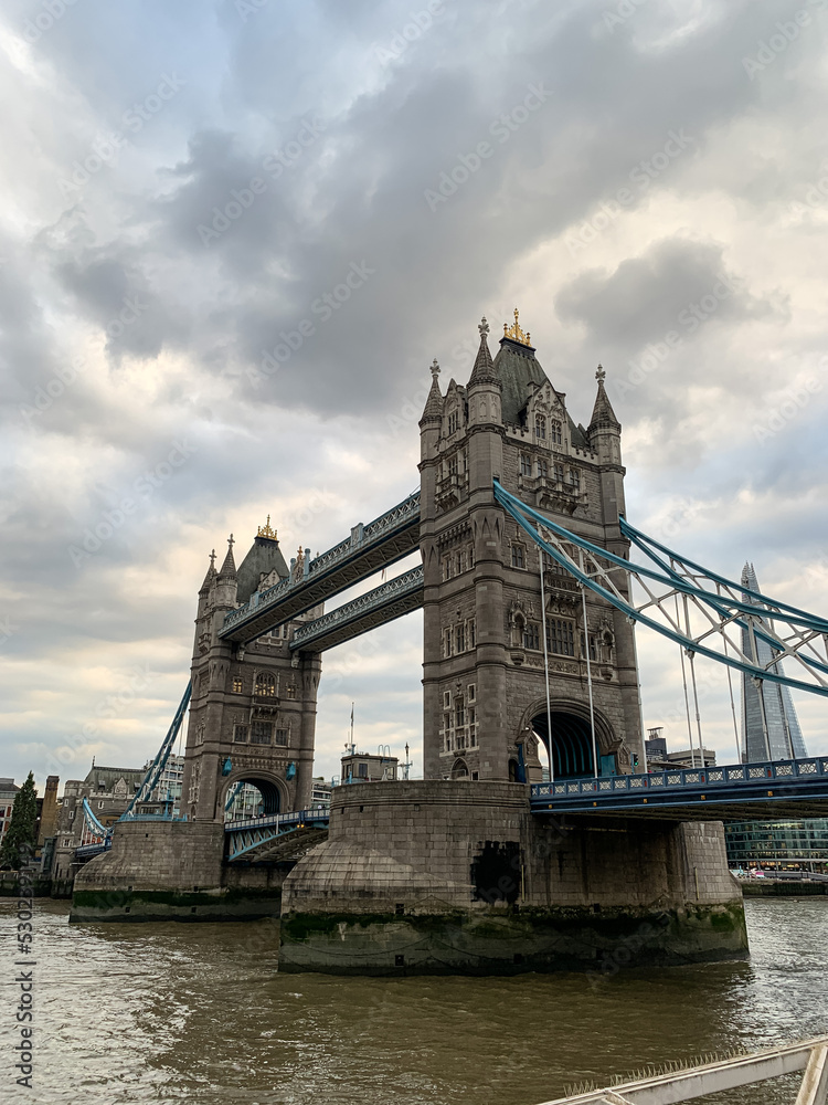 Tower Bridge over Thames river during overcast day in London. Tower bridge above Thames river. One of the main sightseeings in capital of Great Britain. City of London, England, UK