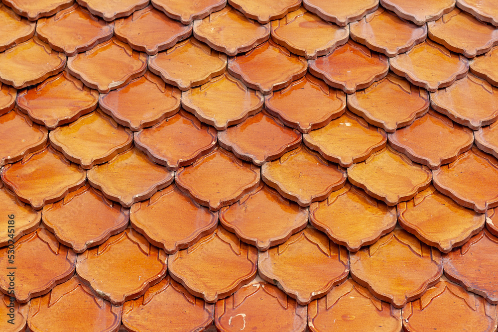 Orange clay tiles overlapping each other on the roof. Geometric pattern from old tile. Selective focus. Shallow DOF. Horizontal. Orange clay tiles overlapping each other on the roof. Geometric pattern from old tile. Selective focus. Shallow DOF. Horizontal.