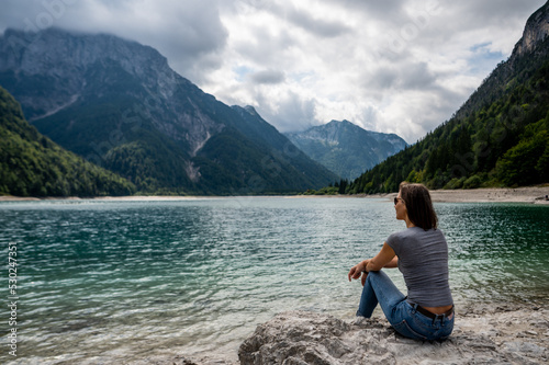 Woman enjoying the mountains view at lakeside in Italy
