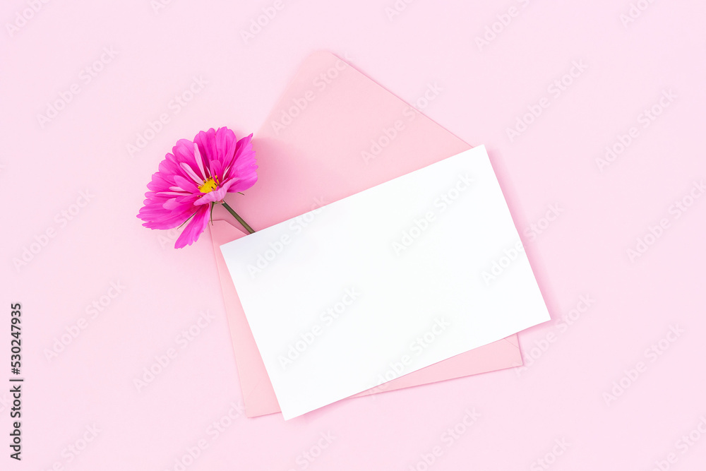 White blank card, pink envelope and flowers on pink background. Minimal style. Top view Flat lay Mockup White blank card, pink envelope and flowers on pink background. Minimal style. Top view Flat lay Mockup
