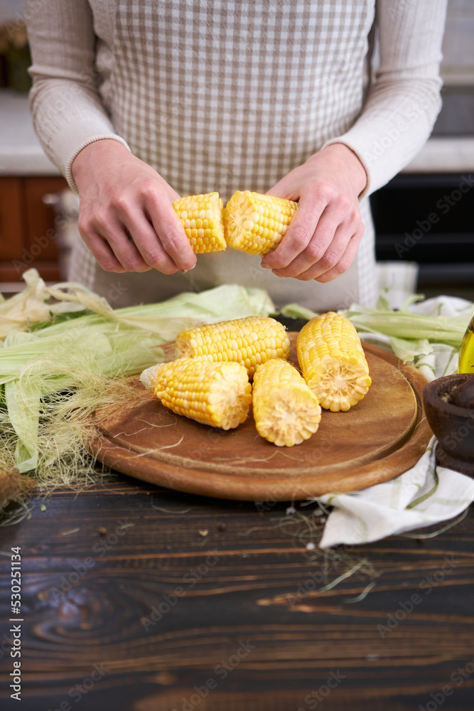 woman holding organic natural corn cob at domestic kitchen woman holding organic natural corn cob at domestic kitchen