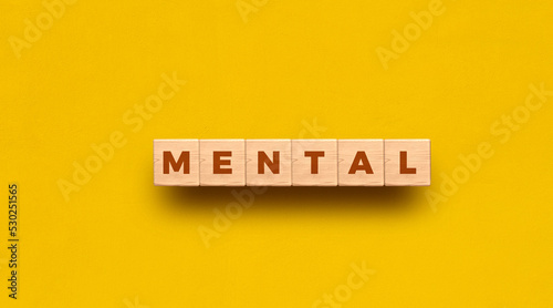Mental word written on wooden blocks with yellow background