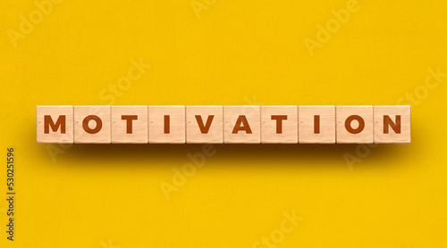 Motivation -  word written on wooden blocks with yellow background
