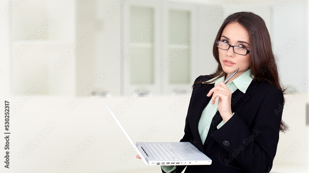 Young woman using laptop computer at home. Female working online.