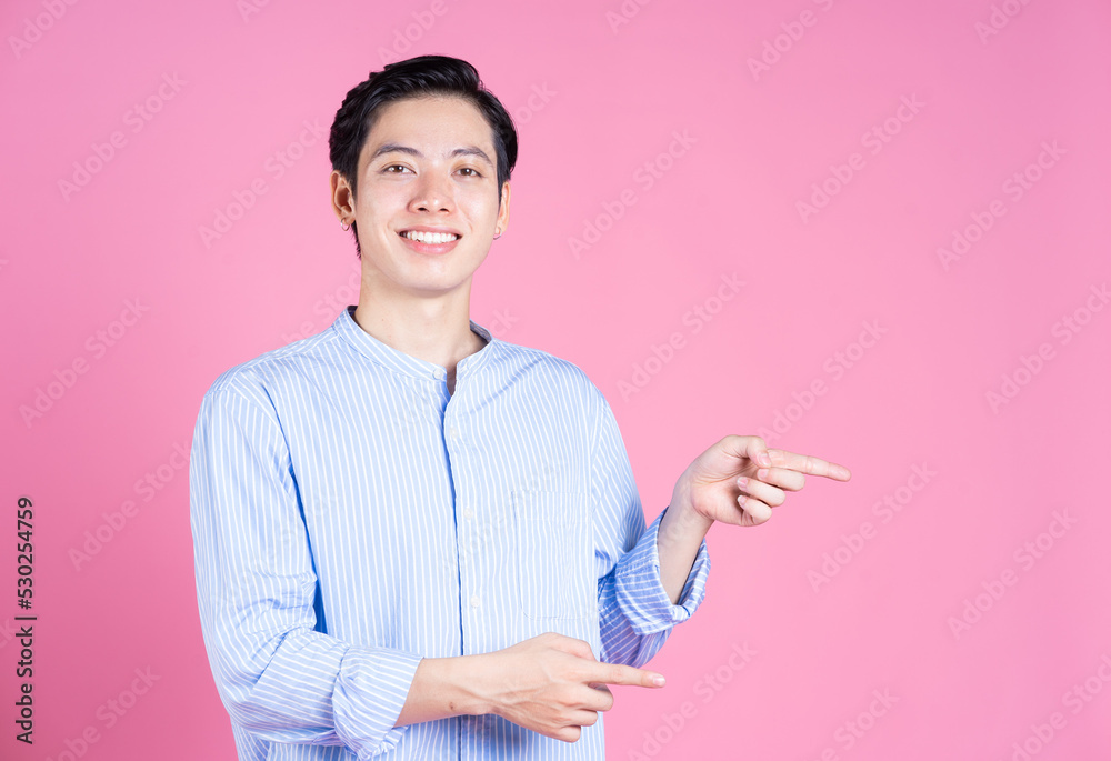 Portrait of young Asian man on pink background Portrait of young Asian man on pink background