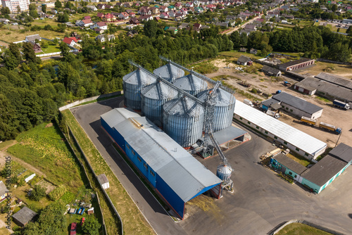 aerial view on rows of agro silos granary elevator with seeds cleaning line on agro-processing manufacturing plant for processing drying cleaning and storage of agricultural products