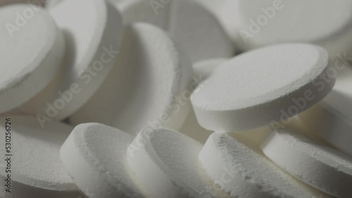 a pile of white pills spins in a circle photo