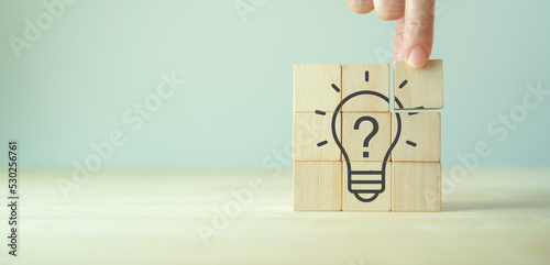 Question marks and light bulb symbolizing idea or solution. Problem solving skill, creativity, innovation, brainstorming, critical thinking and root cause analysis concept. Question, idea and answer.