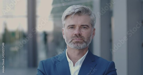 Portrait of Adult Businessman Smiling and Looking Camera Alone. Successful Male Business Man Standing Near Modern Glass Office Center Outdoor. Business People Concept 