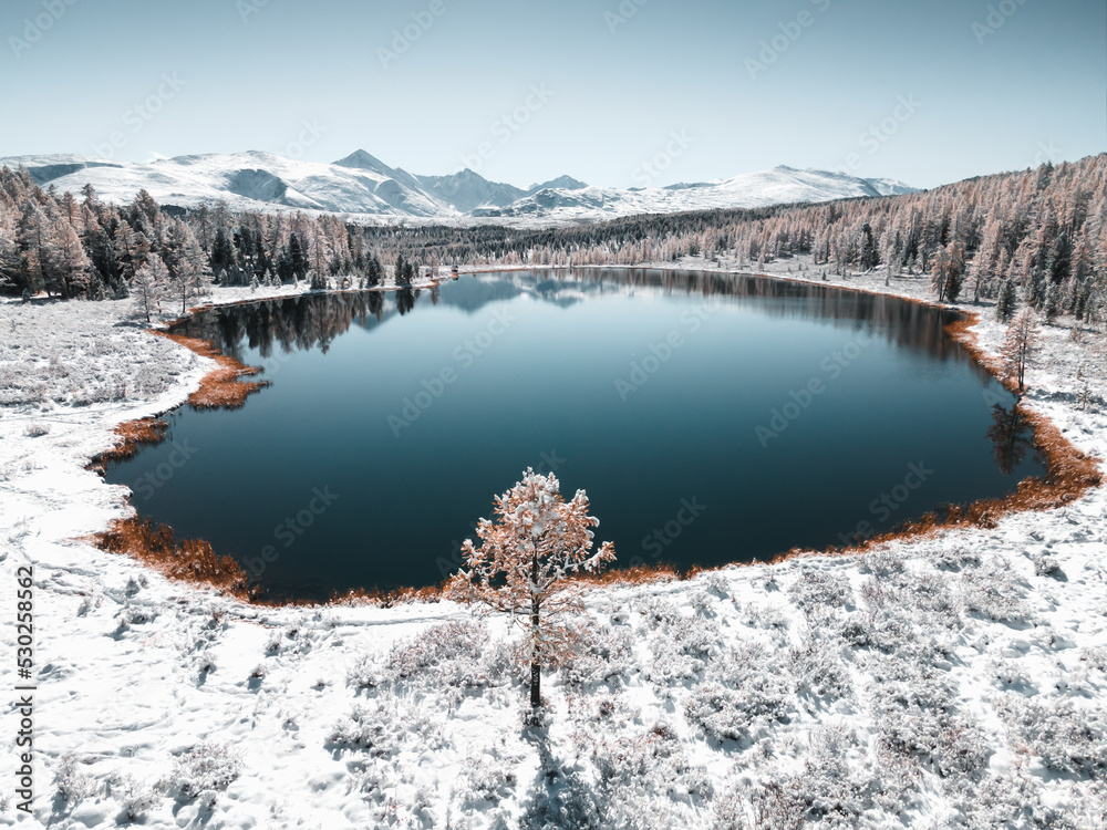 Kidelu lake in Altai mountains, Siberia, Russia. Snow-covered trees and mountains.