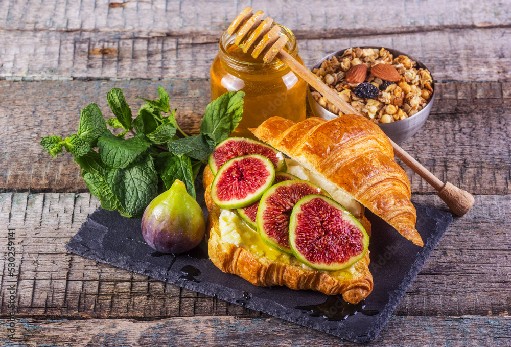 Croissant with ricotta cheese, honey and figs. Delicious breakfast with crispy croissant