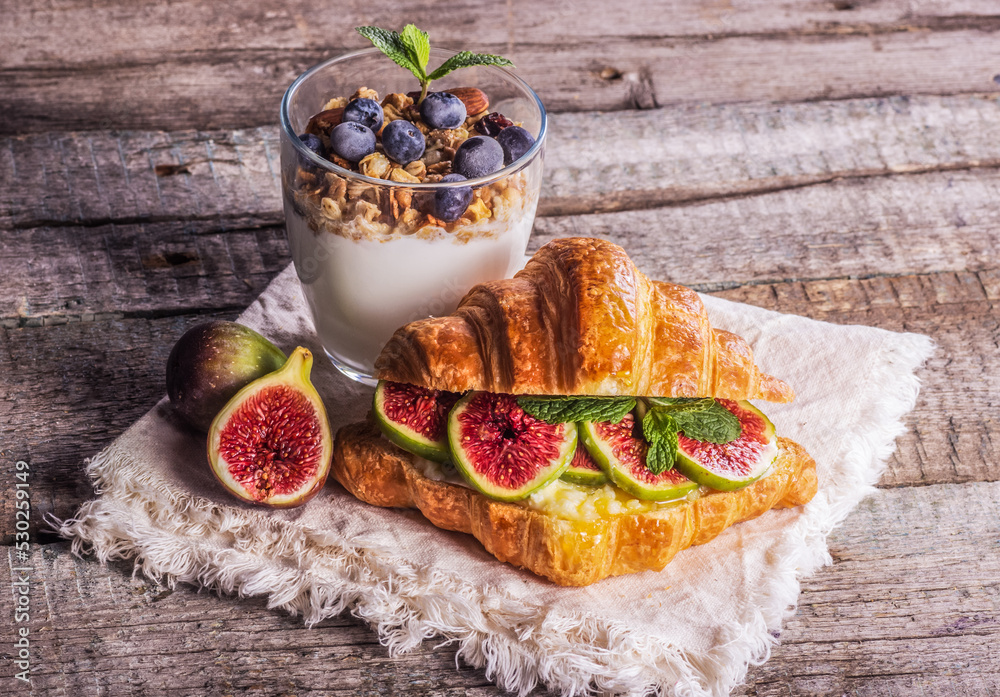 Delicious homemade breakfast with yogurt and croissant. Croissant with figs. Good morning concept