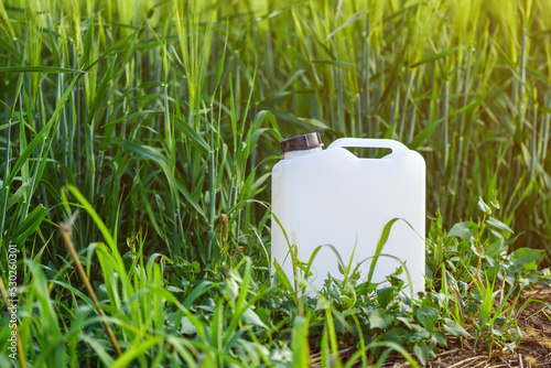 Wallpaper Mural White canister plastic can as herbicide container in cultivated barley crop field with weed Torontodigital.ca