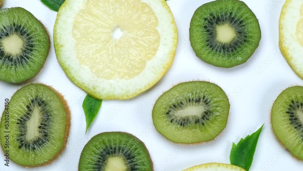 rotating food trendy background of kiwi and lemon or lime slices on white background - healthy eating concept. Summer bright food fruit background, food design rotating food trendy background of kiwi and lemon or lime slices on white background - healthy eating concept. Summer bright food fruit background, food design