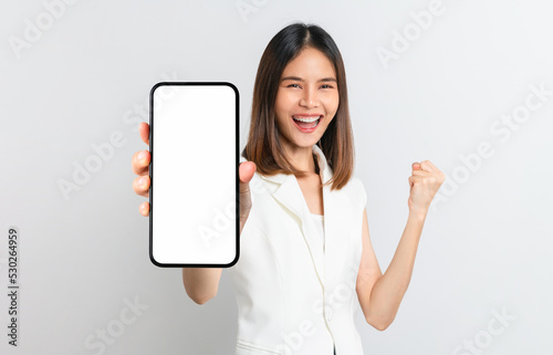 Studio shot of Beautiful Asian woman holding smartphone mockup of blank screen and smiling on white background.