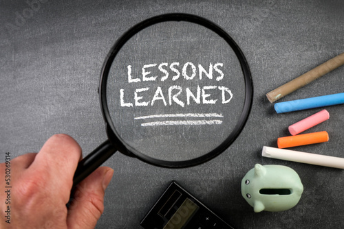 Lessons Learned, Education Concept. Chalk board and magnifying glass