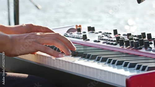 Close Up of keyboard Player Hands Playing Rock Music with keyboard at the Concert at the outdoor wedding party area with Beautiful seascape.