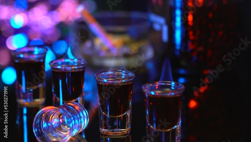 Rum in stacks on the bar counter. Strong alcohol burns in drinks on the background of the bar. Relax in the bar with strong drinks. Fire in the glasses with alcohol. photo