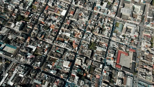 Aerial View Of Traditional Market Plaza de Ponchos In The City Of Otavalo In Andes Mountains, Ecuador. drone tilt-up