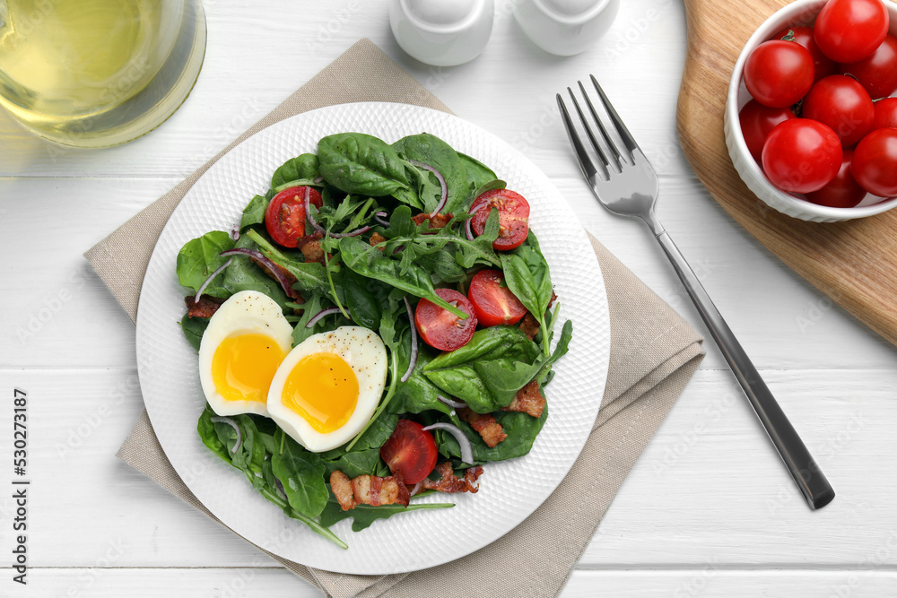 Delicious salad with boiled egg, bacon and tomatoes served on white wooden table, flat lay Delicious salad with boiled egg, bacon and tomatoes served on white wooden table, flat lay