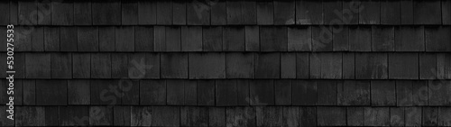 Old black gray grey rustic dark wooden shingle wall facade texture - wood background textured pattern long wide panorama. photo