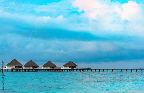 Fototapeta Naklejka Na Ścianę i Meble -  view from sea to island and water villas at day time with blue sky and beautiful clouds in the Maldives, the concept of luxury travel