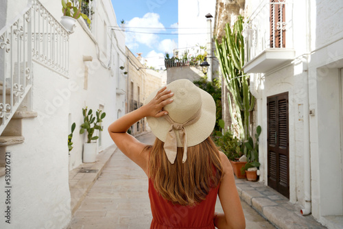 Traveler girl walks through the alleys in a picturesque town in Apulia region, Italy
