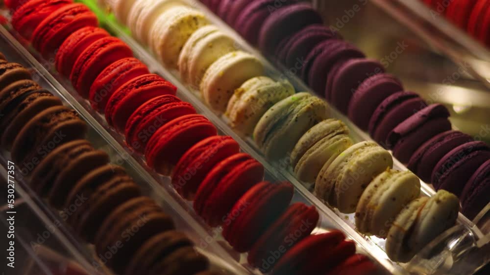 Slowmo pan left, past corner of glass case displaying decadent Paris macarons Slowmo pan left, past corner of glass case displaying decadent Paris macarons