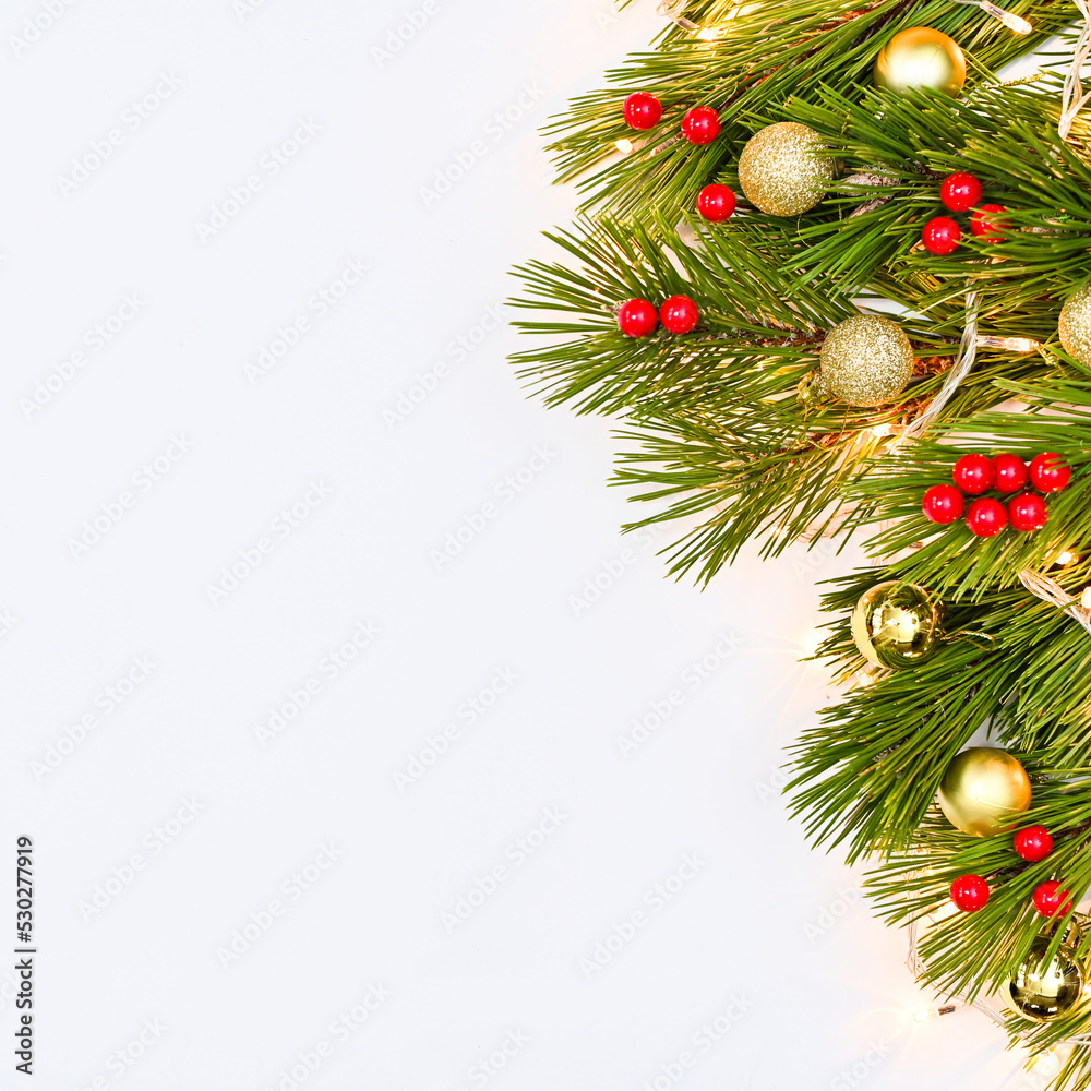 Pine branches decorated with red and gold ornaments on white copy space background. Flat lay