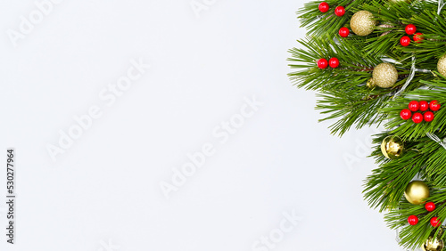 Pine branches decorated with red and gold ornaments on white copy space background. Flat lay