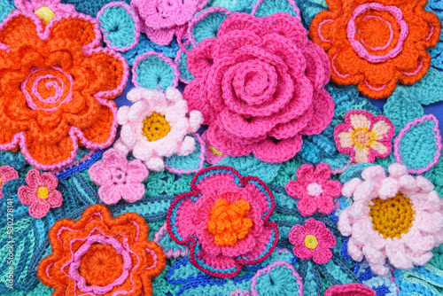 Multicolored handcrafted flowers and leaves, handmade floral background.
