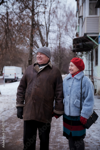 Portrait of elderly man with mature wife on winter city street