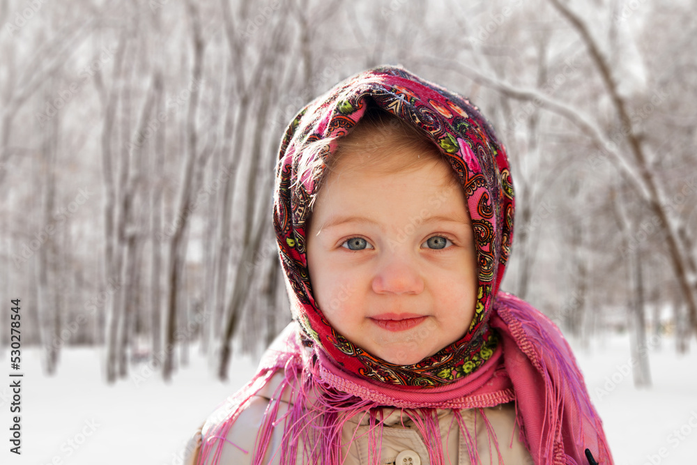 Little girl in headscarf on background of winter landscape Little girl in headscarf on background of winter landscape