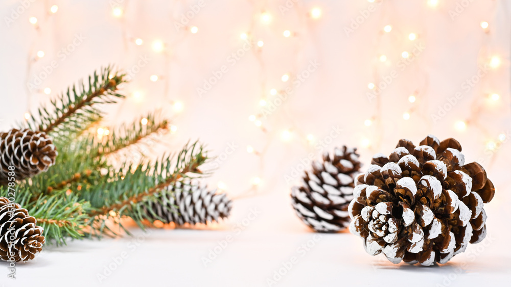 Christmas background with fir branches and pine cones on white theme with lights. Winter holidays concept Christmas background with fir branches and pine cones on white theme with lights. Winter holidays concept