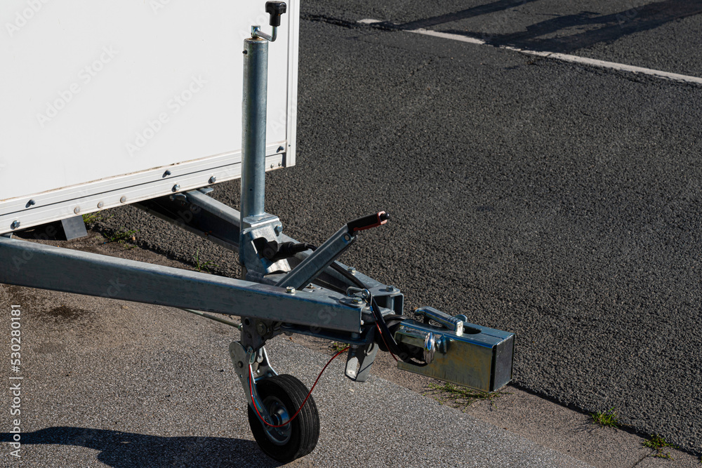 Close-up of the towing device of a car trailer standing on the roadway.