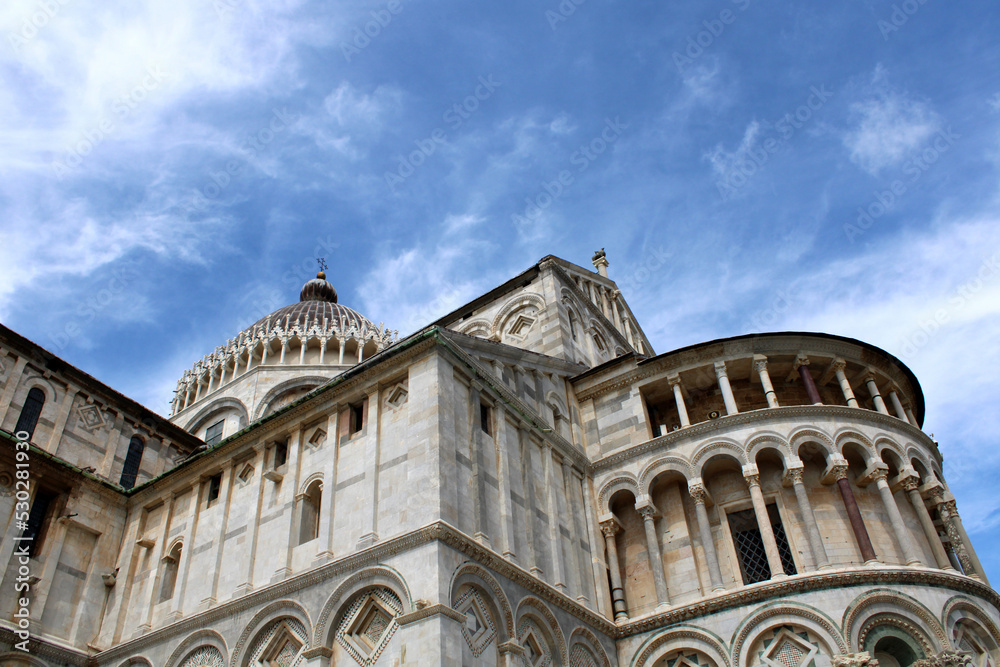 Facciata e colonnato della chiesa di Santa Maria Assunta di Pisa stagliata contro il cielo con nubi