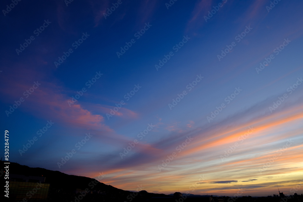 六甲山の朝。東に陽が昇り光の色のグラデーションに雲が染まる