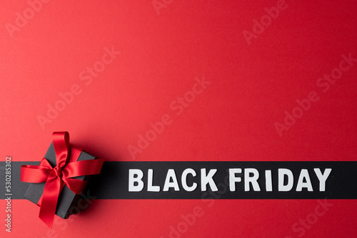 Composition of present with pink ribbon and black friday text on gray and pink background